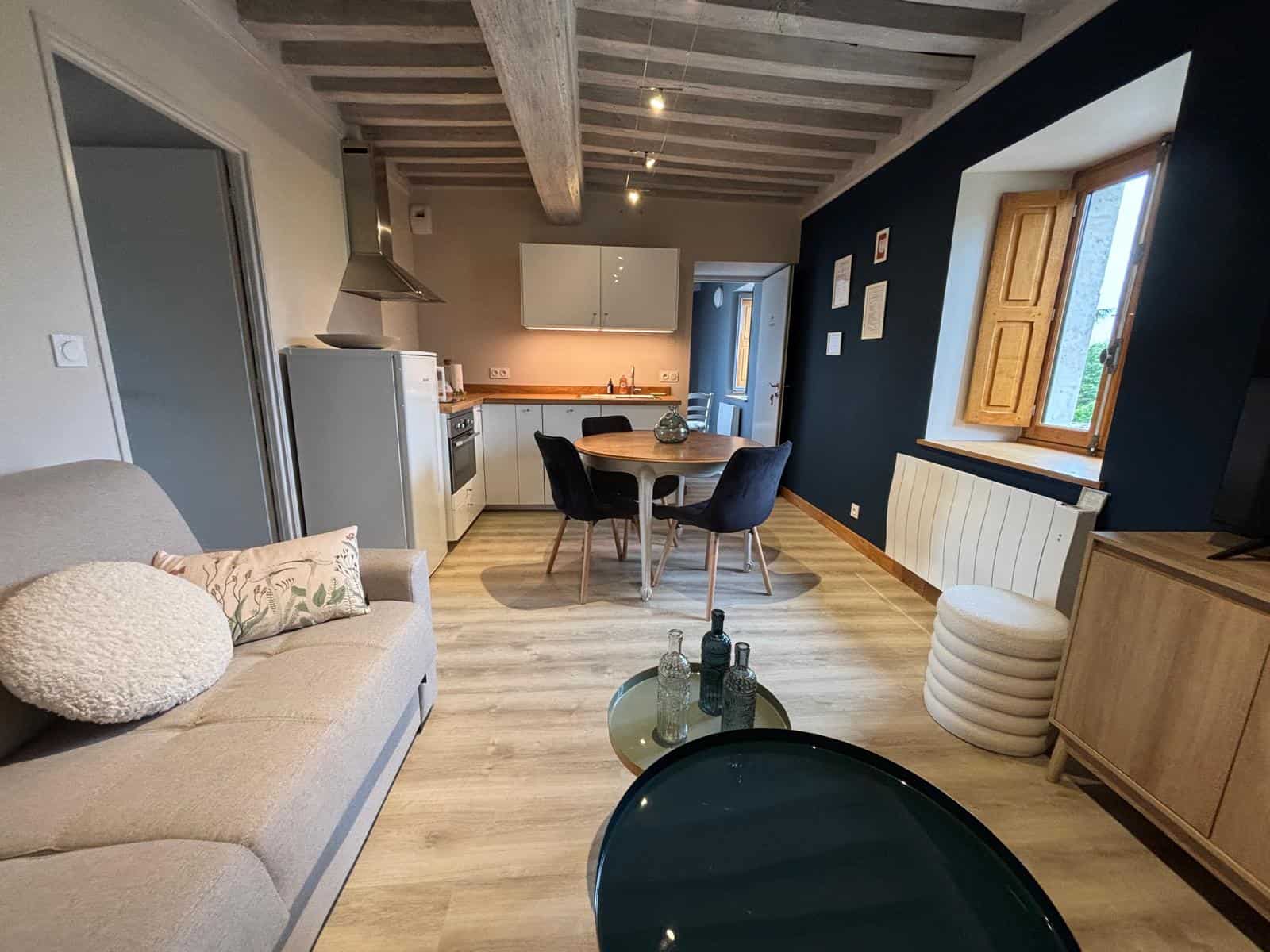 Balcon avec poutres en bois apparentes dans une chambre mansardée du gîte.