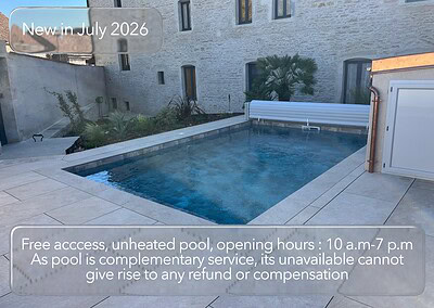 Piscine extérieure chauffée à Mesnil Montrivaut avec jardin et bâtiment historique.