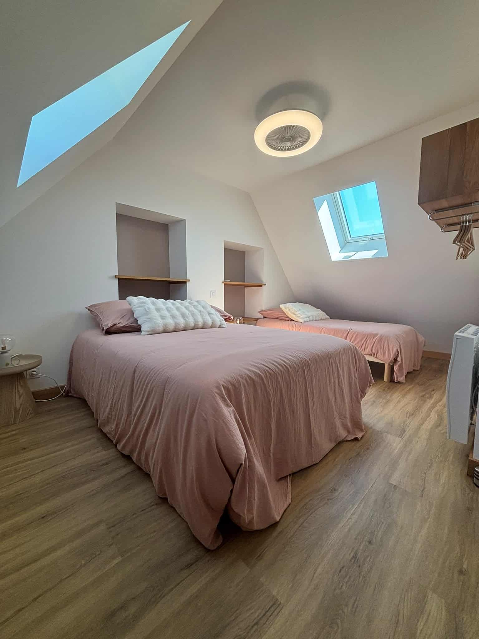 Chambre confortable à Mesnil Montrivaut Chambre lumineuse avec deux lits et fenêtres de toit.